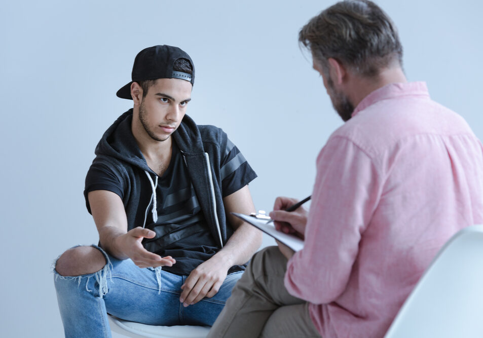 Rebellious spanish man talking to professional psychologist during meeting