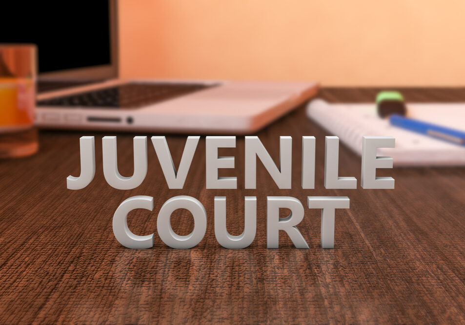 Juvenile Court - letters on wooden desk with laptop computer and a notebook. 3d render illustration.