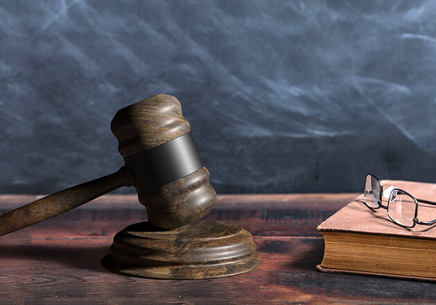 Law gavel, old books and reading glasses on a wooden table, lawyer or judge office desk. 3d illustration