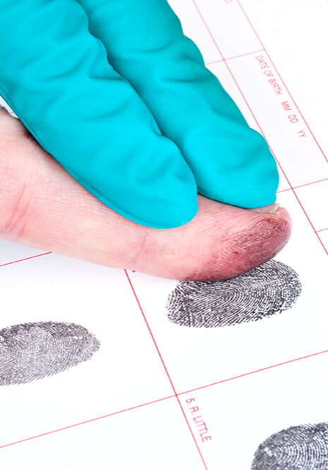 A man is being finger printed for either a crime of for FBI screening on a legal document form.